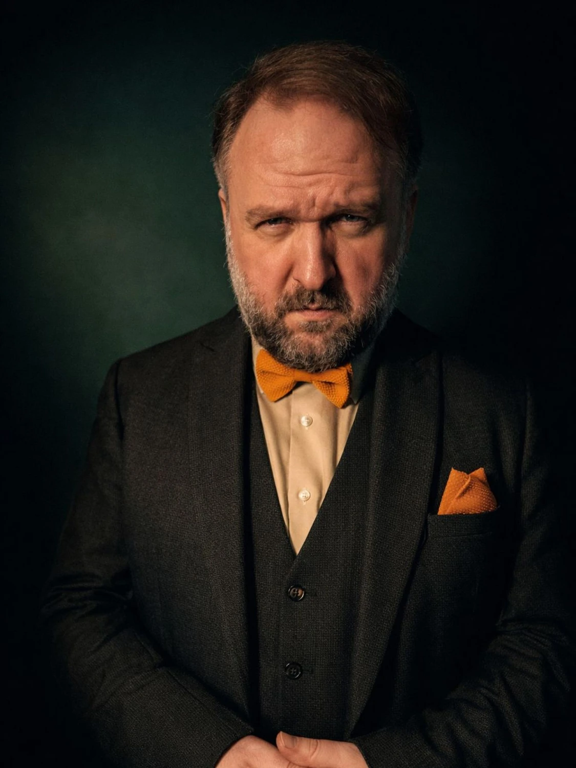 Ronny Schuster im dunklen Anzug mit orangefarbener Fliege.